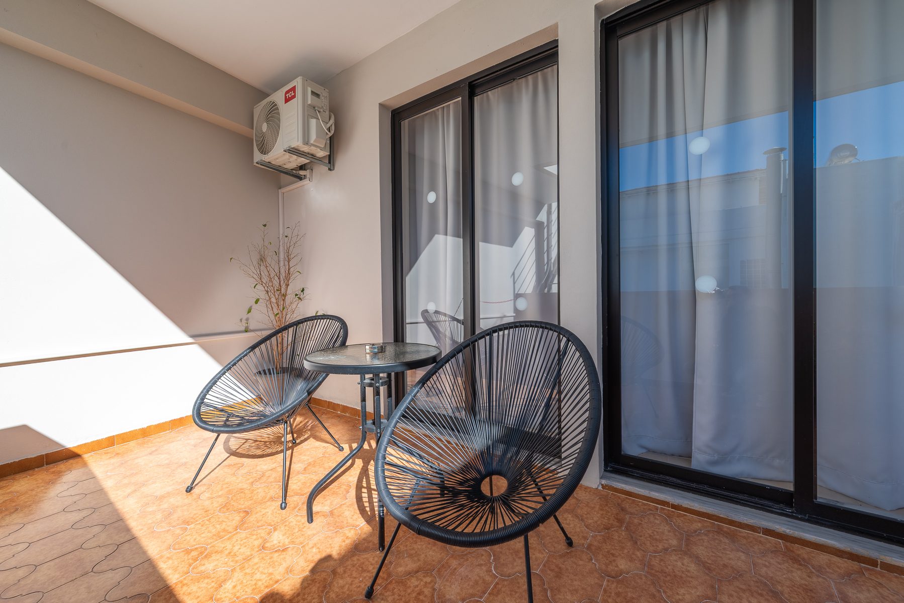 Suite balcony with Acapulco chairs overlooking outdoor space
